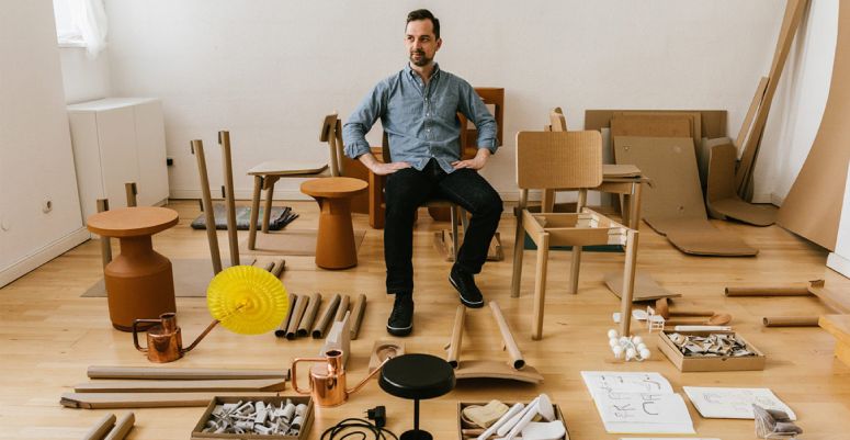 Lighting designer Paul Loebach sits in a room amongst prototyping tools and materials.