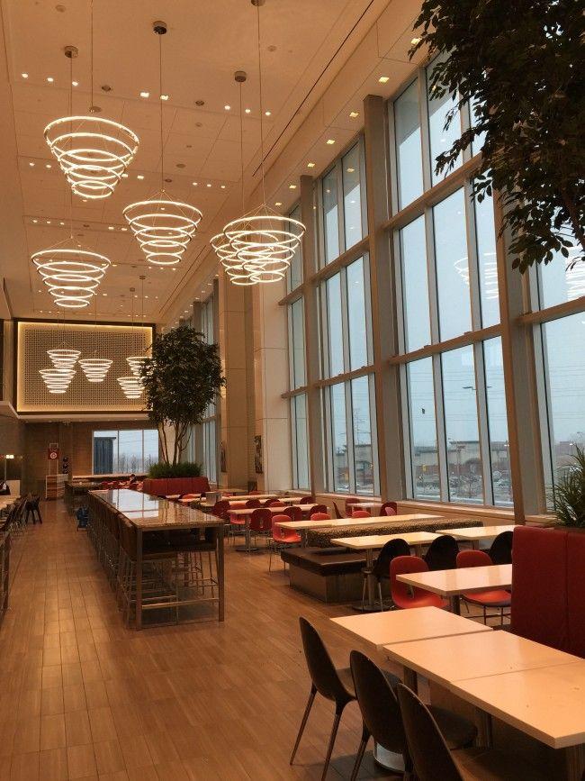 An early-morning photo of the empty food court at Sherway Gardens, illuminated by custom Roll & Hill Halo chandeliers in anticipation of customers arriving.