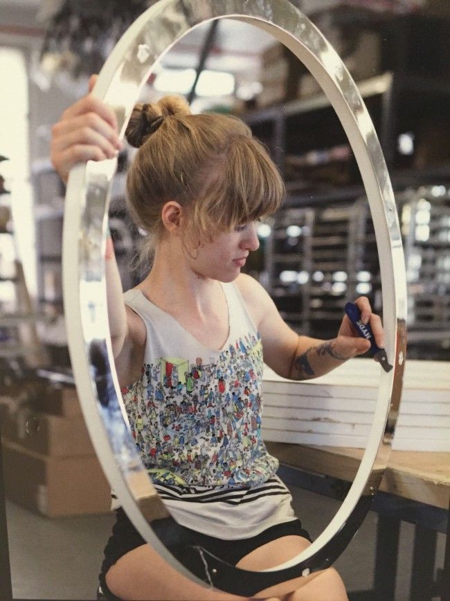 A Roll & Hill craftswoman works on the metal rings that contain the Halo collection's lamping elements.