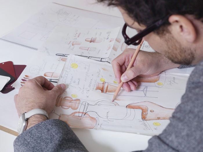 An over-the-shoulder shot of Jaime Hayón as he refines design sketches.