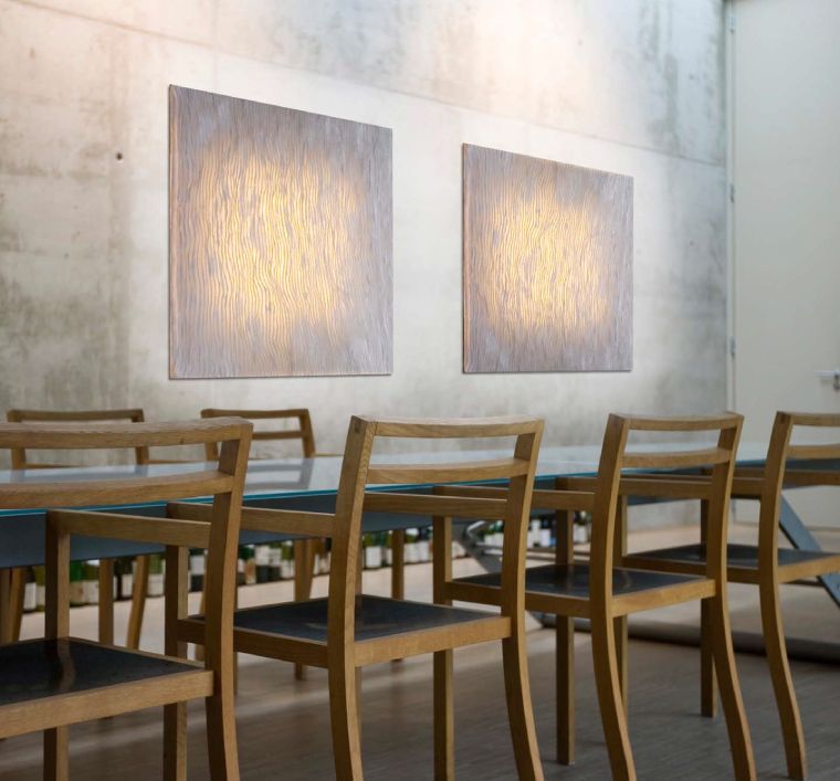 A pair of Planum wall lights from a by arturo alvarez provide ambient lighting for a restaurant seating area.