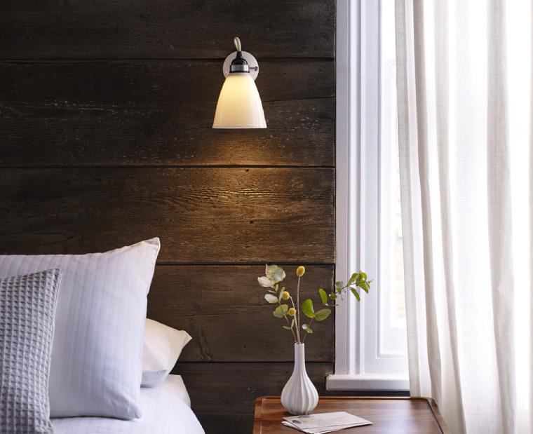 Original BTC's bone china Hector Dome wall sconce serves as a reading light in a luxe hotel.