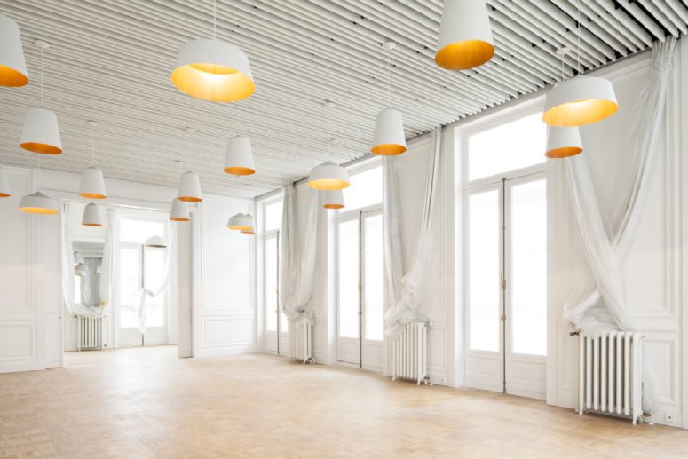 Corinna Warm's Circus pendants from Innermost illuminate a spacious open room at Muntpunt Library, Brussels.