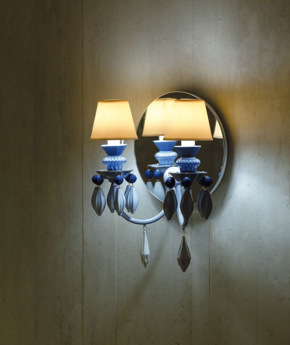 A textured white wall is brought to expressive life under the glow of Belle de Nuit 2 wall sconce, designed through a collaboration between Inma Bermudez and Lladró.