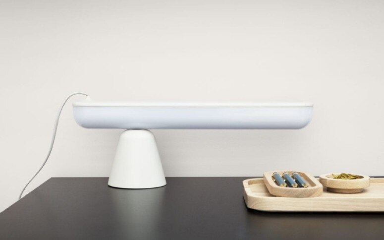 Normann Copenhagen's cantilevered Acrobate table lamp, designed by Marc Venot, sits on a desktop.