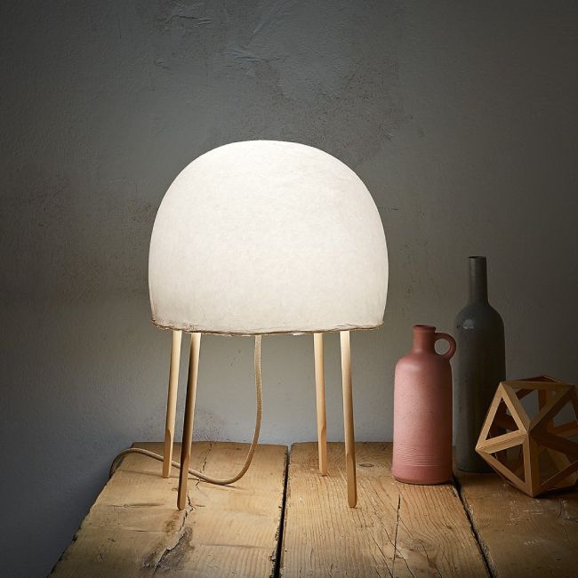 Kurage table lamp from Foscarini sits on a wooden table, adding a Japandi touch.