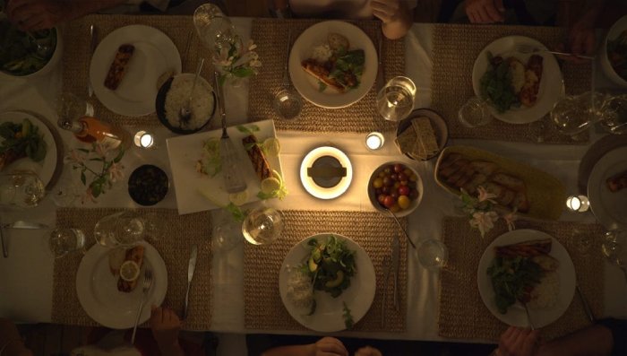 Pablo Designs UMA Sound Lantern serves as the centrepiece for a family dinner, viewed from above.