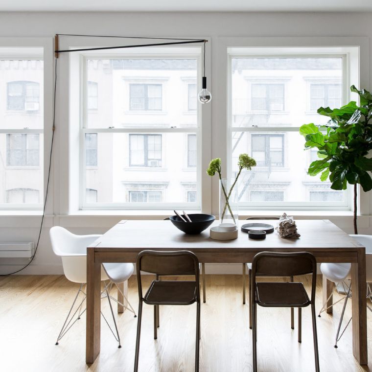 Andrew Neyer's Crane Light wall fixture for his own Stuff label hangs out over a table in an apartment living room from its place affixed to the outer wall.