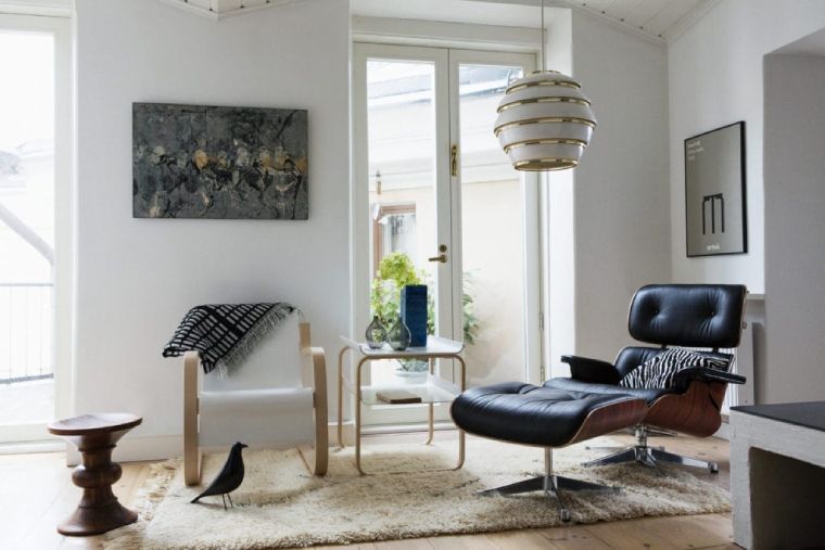 Artek Beehive A331 pendant light, designed by Alvar Aalto, hangs over an Eames chair in a comfortable mid-century modern space.