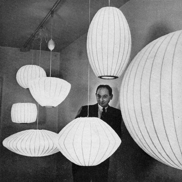 Legendary lighting designer George Nelson poses with the full collection of Nelson Bubble Lamp suspension lights.