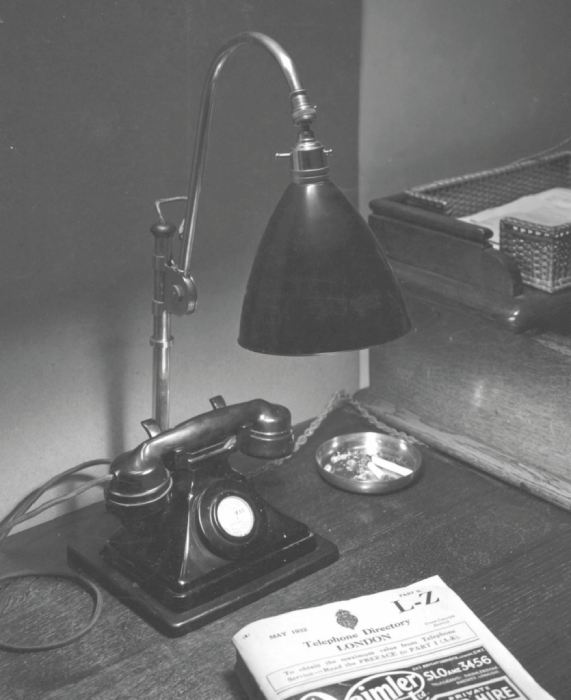 A vintage photo of the BestLite table lamp on an old telephone desk.