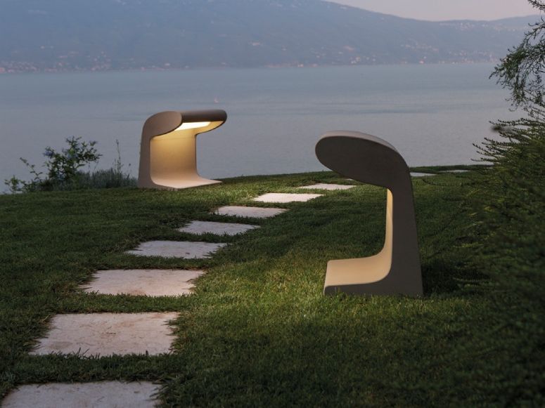 The solid and substantial Nemo Borne Béton Grande outdoor floor lights, designed by legendary designer Le Corbusier, flank a path of pavement stones on a hillside overlooking a lake.