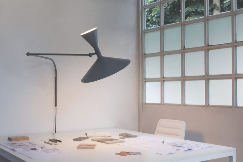 Le Corbusier's versatile Lampe de Marseille wall light provides amble adjustable light over a desk and workspace in a clean, bright office.