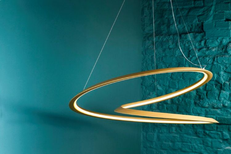 Nemo's Kepler suspension light, designed by Arihiro Miyake, hangs in front of a rough-finished wall painted in aquamarine