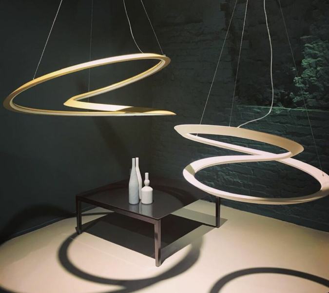 A pair of Kepler suspension lights from Nemo illuminate a corner end table in a studio photo.