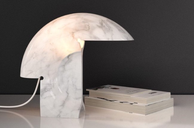 FLOS' marble Biagio table lamp sits on a white desktop overlooking some books.