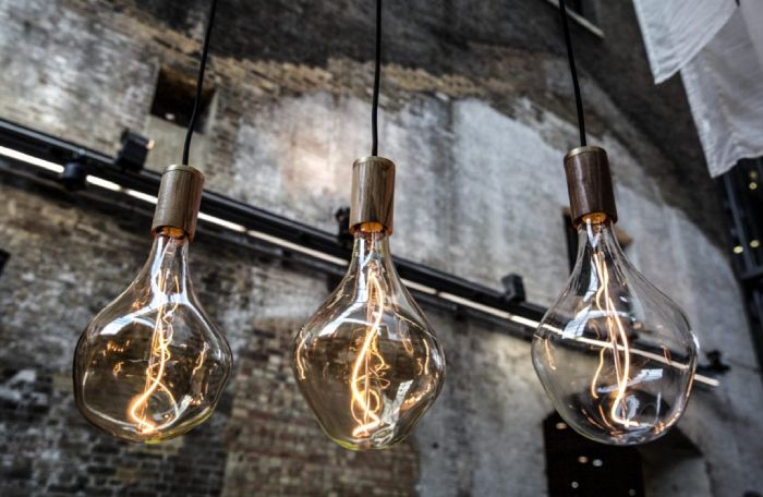 A trio of Voronoi II pendant lights hanging in a linear cluster in an industrial factory setting.