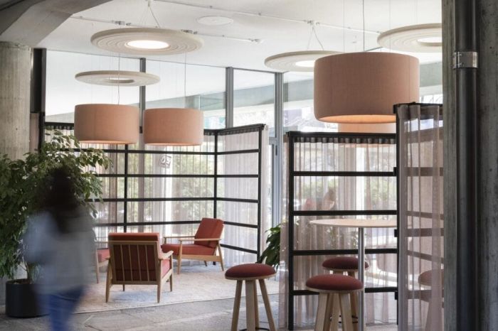 A contemporary office with BuzziSpace's BuzziJet pendant lights hanging over a small meeting area