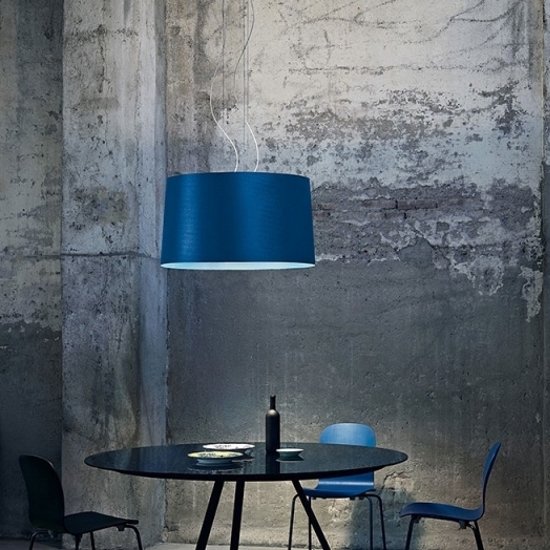 Twice as Twiggy suspension light in blue, designed for Foscarini by Marc Sadler, illuminates a sleek black café table.