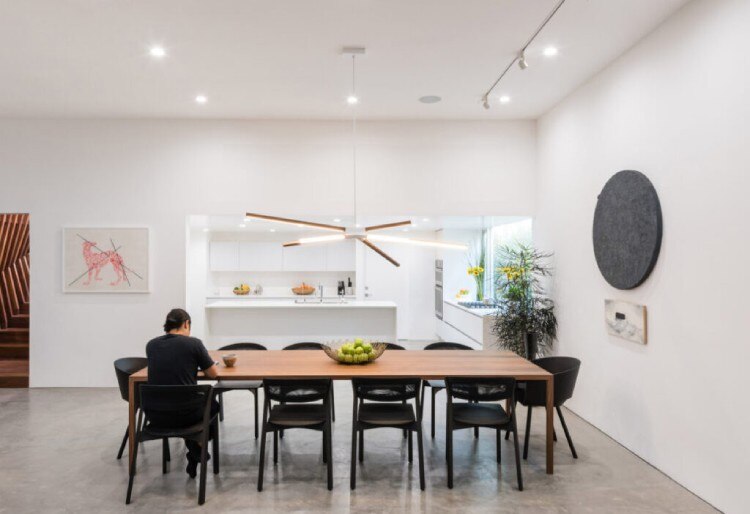 A bright and spacious dining room with Stickbulb's Skybang suspension light over the wooden dining table.