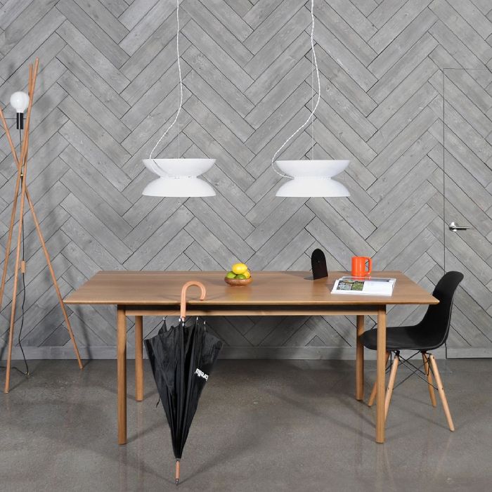 A pair of Yoyo pendant lights in white hang above a wooden dining table.