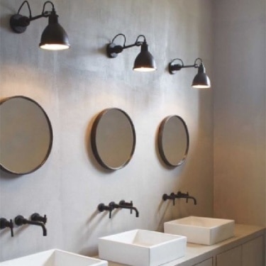 A public washroom uses the iconic Lampe Gras to illuminate a series of sinks.