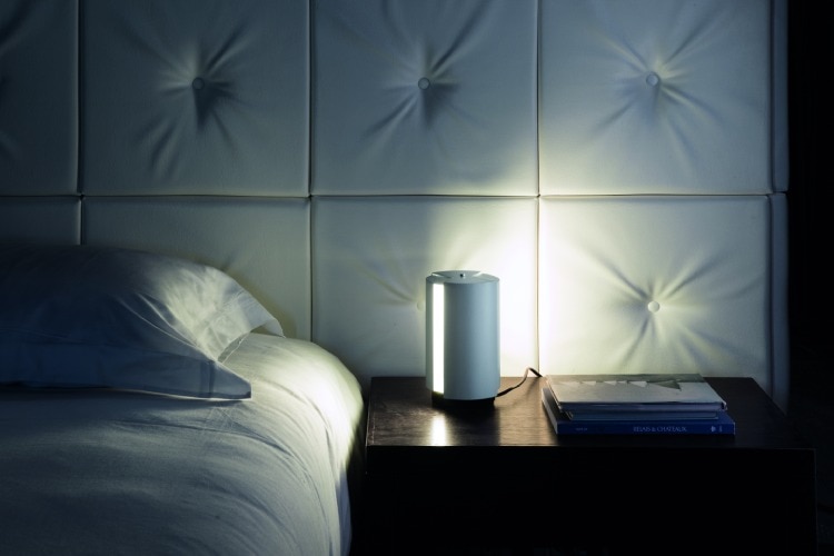 Pivotante à Poser table light, designed by Charlotte Perriand and released by Nemo, sits bedside, with its dual shades positioned to provide a soft glow.