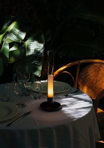 Sylvestrina portable table light throws soft light over a table for two with a dramatic slash of sunlight across the shadows.