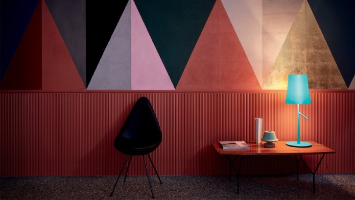 A memphis-inspired room is illuminated by Birdie table lamp by Ludovica and Roberto Palomba.