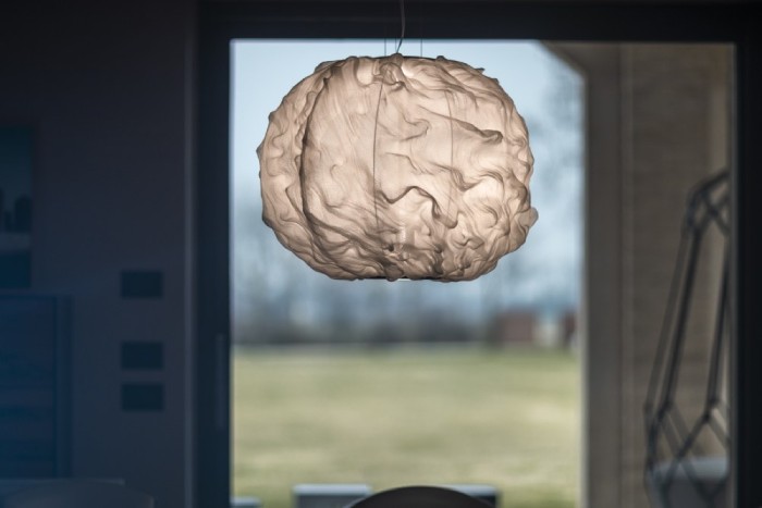 Marc Sadler's Nuée suspension light for Foscarini hangs in a rustic dining room.