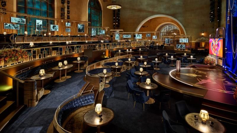 The stage and audience of the 93rd Academy Awards, designed by David Rockwell and built in Union Station in Los Angeles due to covid safety protocols. By relying primarily on blue, bronze, and black, Rockwell evoked the Modern Glam design style.