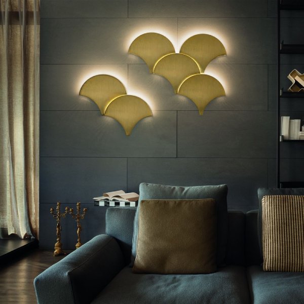 A cluster of Palm A wall sconces interlocked and illuminated on a living room wall.