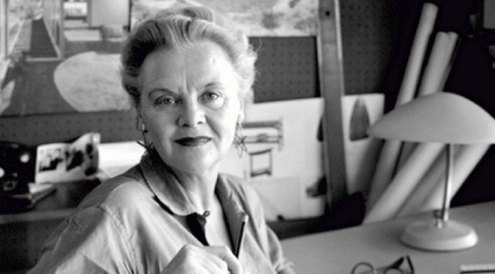 Greta Magnusson Grossman, in her later years, at her desk. Her own Cobra table lamp sits upon the desk's surface.