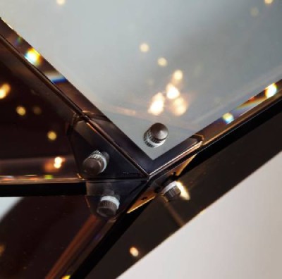 A close-up of four refined glass panes meeting at a corner of Maxhedron Horizontal 30 inch pendant light.