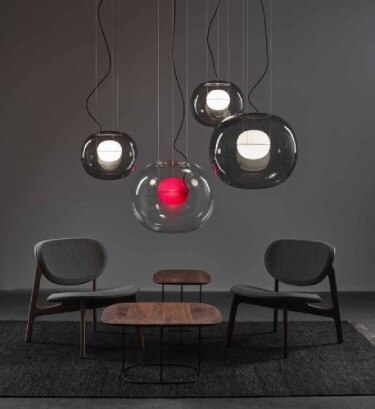 A cluster of Lucie Koldova's Big One pendants hang over a small sitting area.