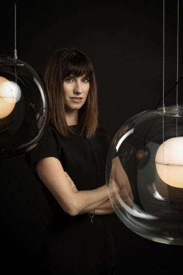 Lighting designer Lucie Koldova in a moody photo with Big One suspension lights.