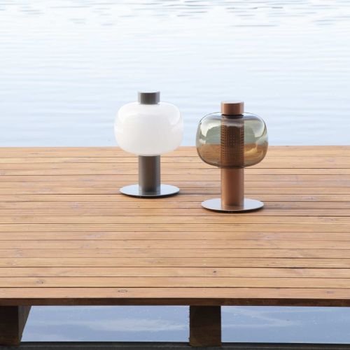 Two Bonbori Outdoor floor lamps on a dock over water.