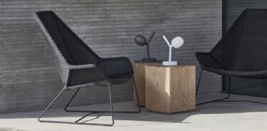 Ivy Battery portable outdoor table lamp, designed by Lucie Koldova for Brokis, on a sunlit patio.