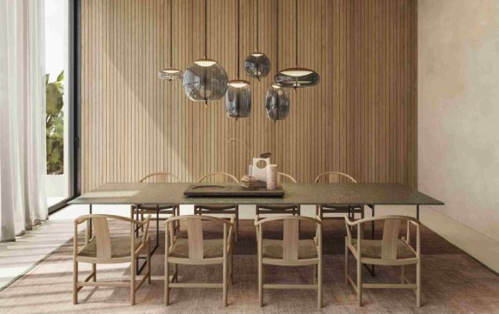 A cluster of various Knot family pendants designed by Chiaramonte Miran for Brokis hangs above a dining room table.