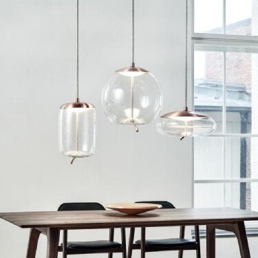 A cluster of Brokis' Knot pendant lights over a dining room table