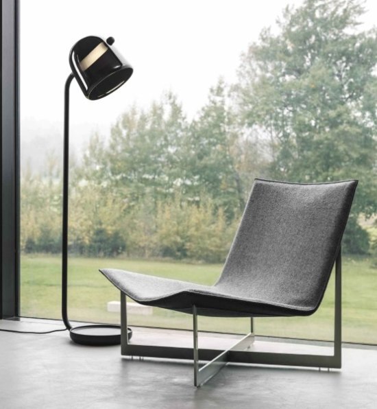 Lucie Koldova's Mona floor lamp illuminates a chair in a sleekly modern study.