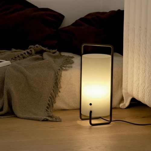 Santa & Cole's Asa table lamp by Miguel Milá sits on the floor bedside.