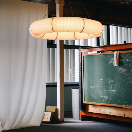 Santa & Cole's Tekio Circular P8 suspension light by Anthony Dickens, suspended in a workshop.