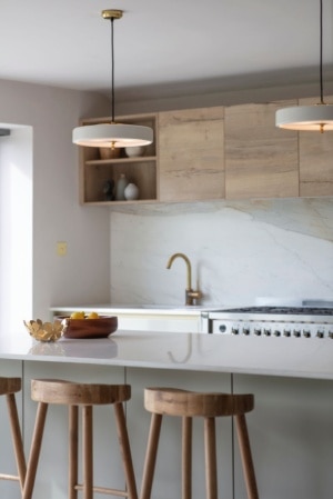 A pair of Revolve pendants from Bert Frank illuminate a bright contemporary kitchen.