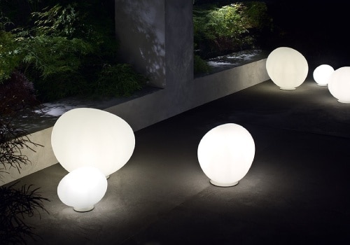 A selection of Gregg Large table lights, designed for Foscarini by Ludovica and Roberto Palomba, illuminate a darkened walkway.