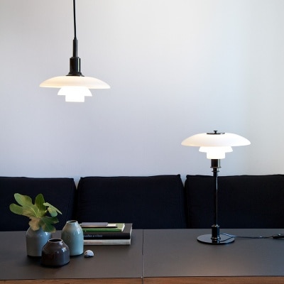 Louis Poulsen's PH 3/2 pendant and table lights, designed by Poul Henningsen illuminate a study area in a living room