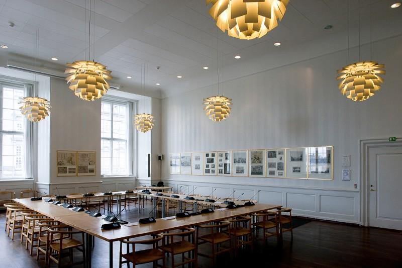 A meeting room at Folketing, the Danish Parliament, illuminated by several Artichoke pendant lights, designed by Poul Henningsen