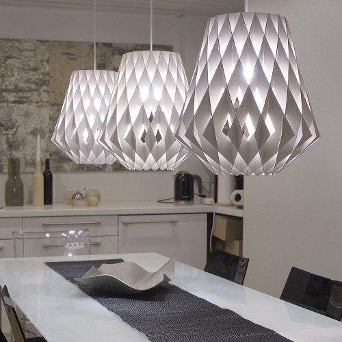 A linear cluster of Pilke P36 Pendant suspension lights hang over a dining table.