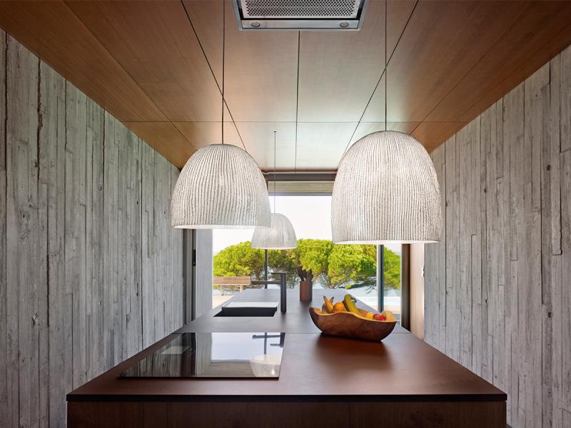 a-emotional light's Onn pendant lights by Arturo Alvarez hang above a sleek minimalist kitchen's counter.