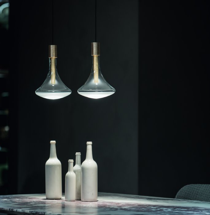 Omar Carraglia's Cathode pendant for Davide Groppi hangs over a table.